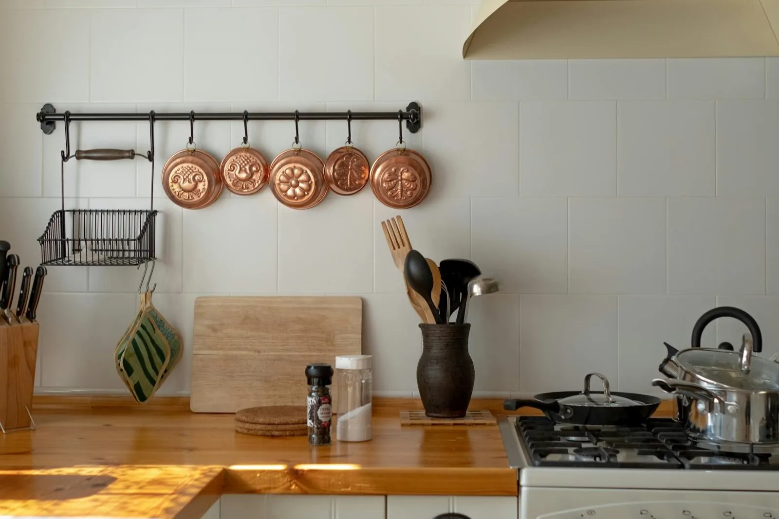 Cozinha aconchegante com panelas e utensílios em destaque.